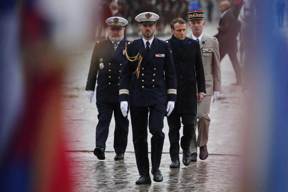 French President Emmanuel Macron, second right, arrives at the Arc de Triomphe in Paris Monday Nov. 11, 2019 before the start of the commemorations marking the 101st anniversary of the 1918 armistice, ending World War I. (AP Photo/Francois Mori, Pool)