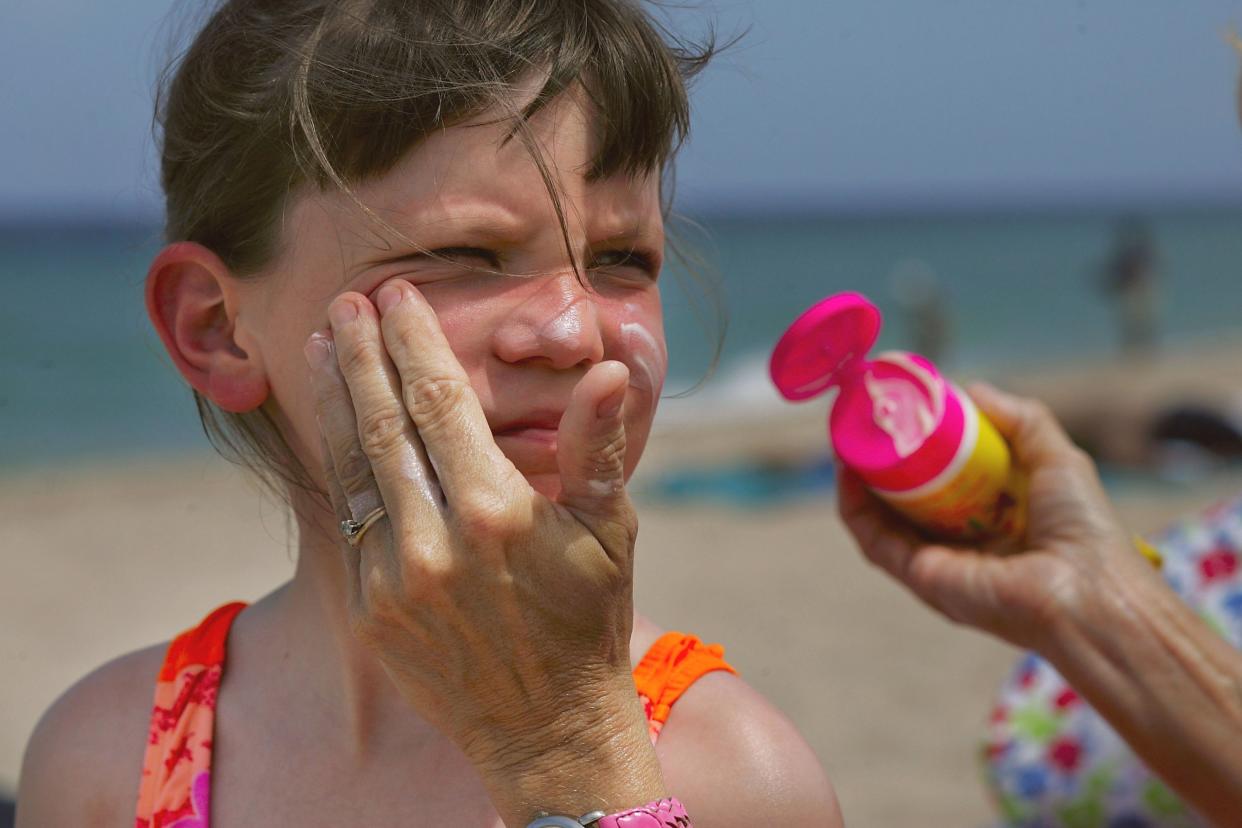 Sharon Doyle puts sunscreen on the face of 9-year-old Savannah Stidham as they visit the beach in Fort Lauderdale, Fla. (Photo by Joe Raedle/Getty Images)