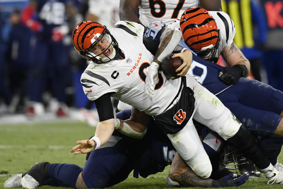 Tennessee Titans' Anthony Rush and Harold Landry sack Cincinnati Bengals quarterback Joe Burrow (9) during the second half of an NFL divisional round playoff football game, Saturday, Jan. 22, 2022, in Nashville, Tenn. (AP Photo/Mark Zaleski)