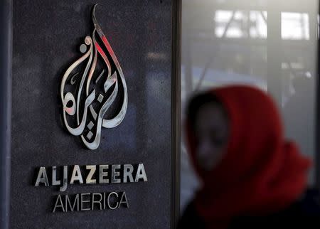 A woman passes by the Al Jazeera America broadcast center in midtown Manhattan in New York City January 13, 2016. REUTERS/Brendan McDermid