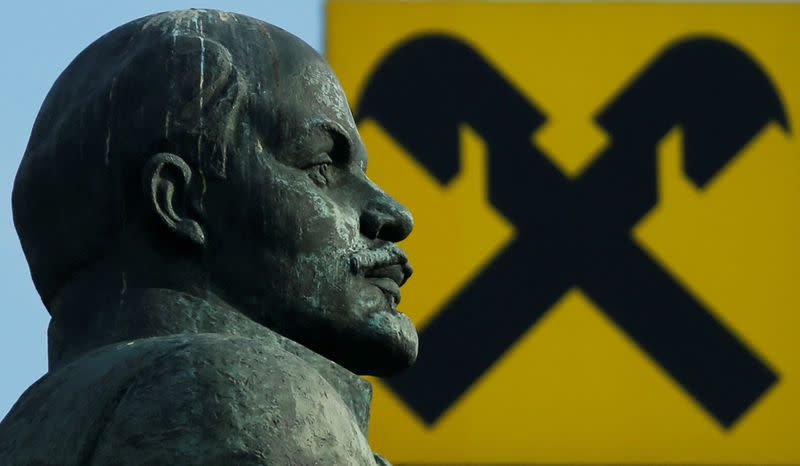 FILE PHOTO: Statue of Soviet state founder Lenin is seen in front of logo of Raiffeisen Bank in Moscow