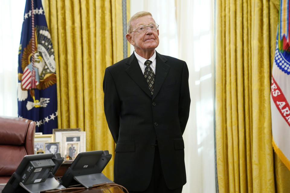 Former college coach Lou Holtz listens to President Donald Trump speak before being awarded the medal of Freedom, the highest civilian honor, in the Oval Office at the White House, Thursday, Dec. 3, 2020, in Washington. Holtz had a storied 34-year coaching career that included winning the 1988 national title at the University of Notre Dame. (AP Photo/Evan Vucci)