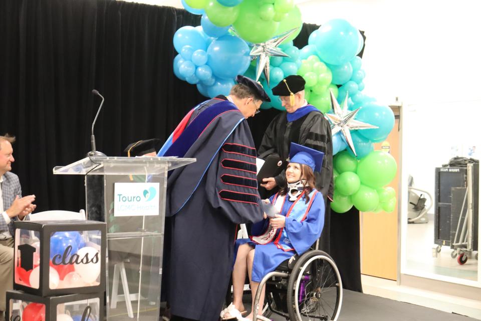 MacKenzie Maier accepts her diploma from Louisiana Tech University President Les Guice June 23 at Touro Rehab in New Orleans. Standing behind Maier is College of Applied and Natural Sciences Dean Dr. Gary Kennedy.