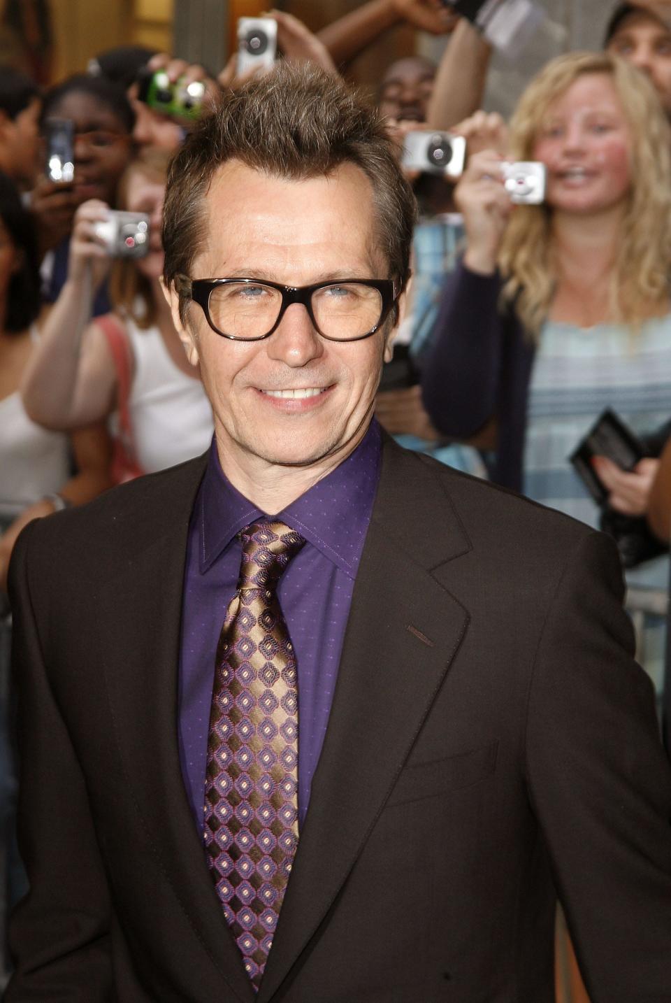 Gary Oldman in a dark suit and tie