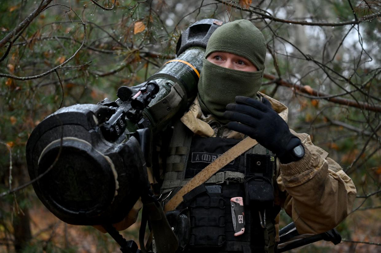 A Ukrainian border guard carries an Anglo-Swedish NLAW anti-tank missile launcher near the Ukrainian border with Russia and Belarus