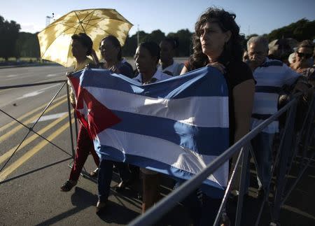 Mourners carry a Cuban flag as they wait in line to pay tribute to Cuba's late President Fidel Castro in Havana, Cuba, November 28, 2016. REUTERS/Alexandre Meneghini