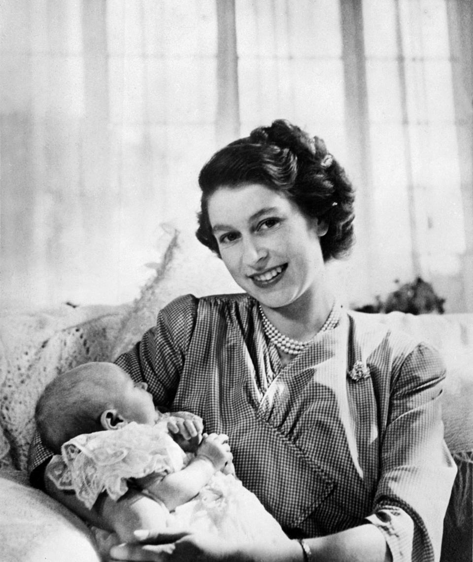 Then-Princess Elizabeth smiles as she holds Princess Anne in her lap