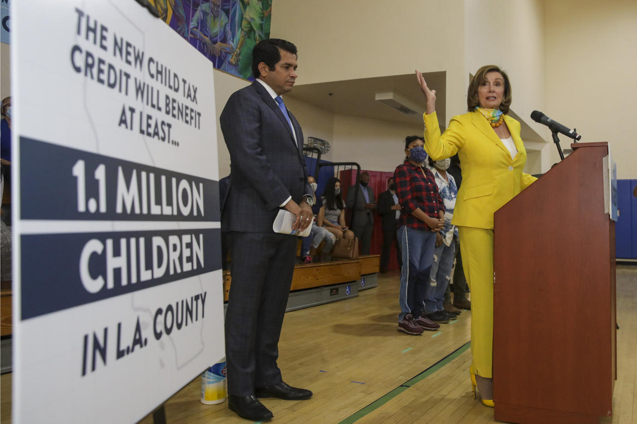 Los Angeles, CA - July 15: U.S. Representative Jimmy Gomez, left, watches as House Speaker Nancy Pelosi, talks about the expanded Child Tax Credit at a press conference held at Barrio Action Youth and Family Center on Thursday, July 15, 2021 in Los Angeles, CA. (Irfan Khan / Los Angeles Times via Getty Images)