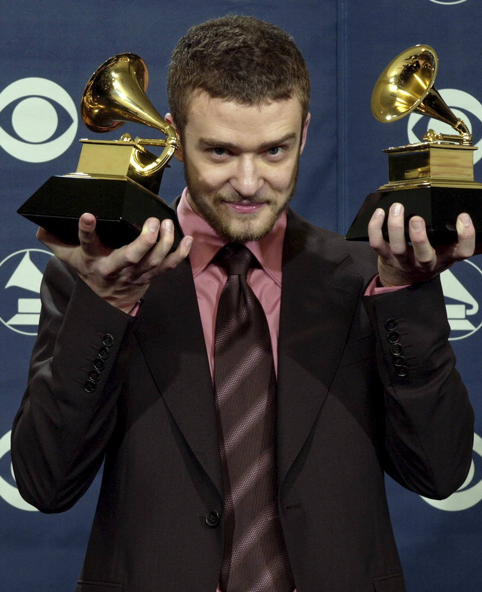 FILE - Justin Timberlake holds the awards he won for best male pop vocal performance and best pop vocal album at the 46th Annual Grammy Awards, Sunday, Feb. 8, 2004, in Los Angeles. (AP Photo/Reed Saxon, File)