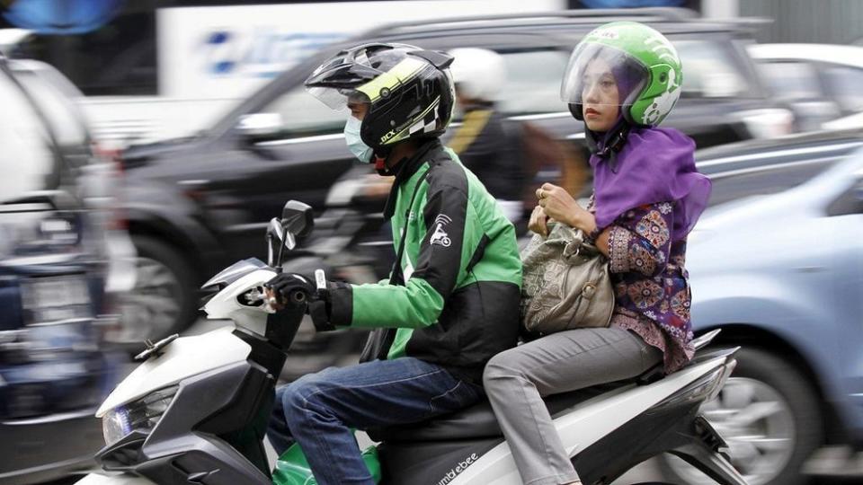 A women uses the Go-Jek service in Jakarta. — Reuters file pic