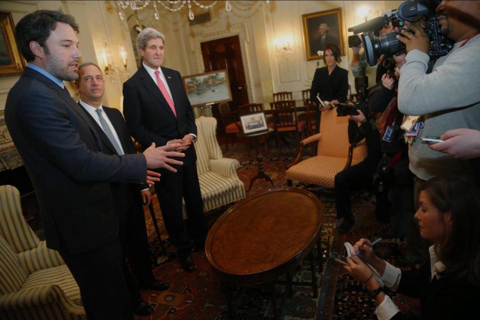 Actor Ben Affleck, left, answers a reporter's question as US Special Envoy for the Great Lakes Region of Africa Russ Feingold, center, and Secretary of State John Kerry listen during a photo opportunity before their meeting about Congo, Wednesday, Feb. 26, 2014, at the State Department in Washington. (AP Photo/Charles Dharapak)