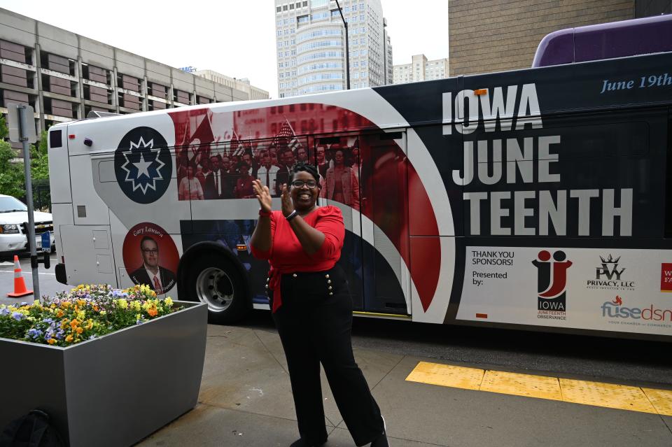 Members of the public and Dwana Bradley, general chairperson of nonprofit organization Iowa Juneteenth, unveil the Juneteenth-themed DART bus that will be in operation during the month of June.