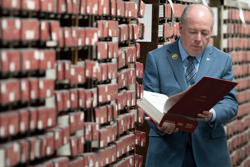 Bergen County Clerk John Hogan stands among the documents which have been digitalized. The documents include deeds and land records dating back to the 1800s which will now be available online.