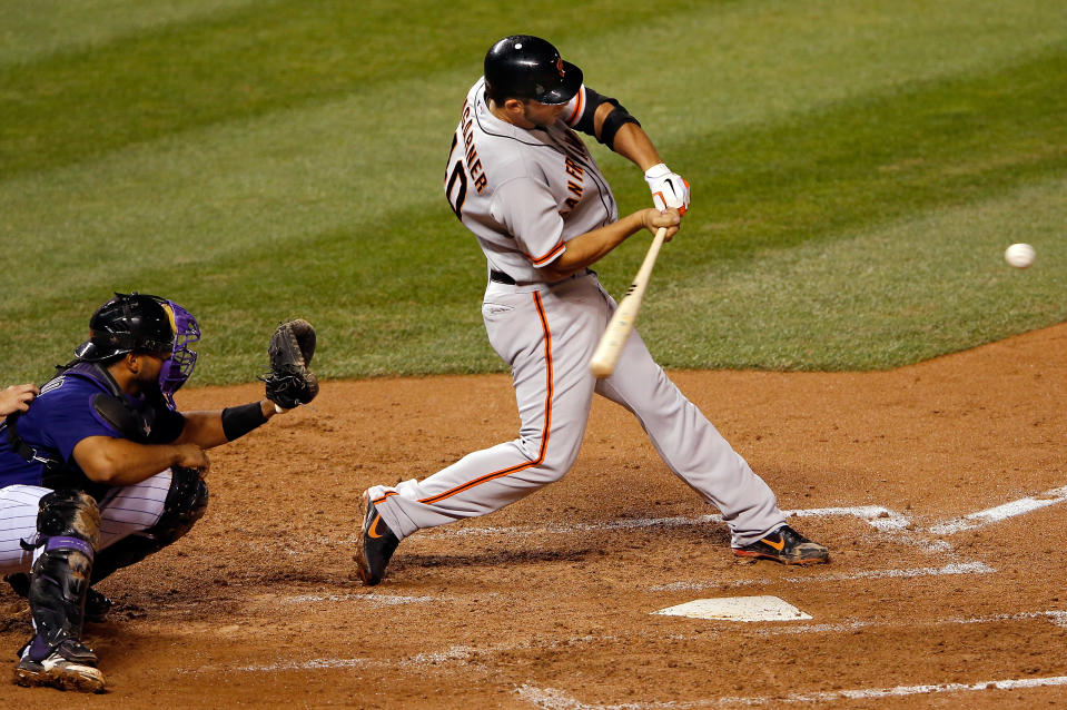 DENVER, CO - SEPTEMBER 11:  Starting pitcher Madison Bumgarner #40 of the San Francisco Giants hits a three run homerun off of starting pitcher Jhoulys Chacin #45 of the Colorado Rockies to tie the score 4-4 as catcher Wilin Rosario #20 of the Colorado Rockies backs up the plate at Coors Field in the fourth inning on September 11, 2012 in Denver, Colorado.  (Photo by Doug Pensinger/Getty Images)