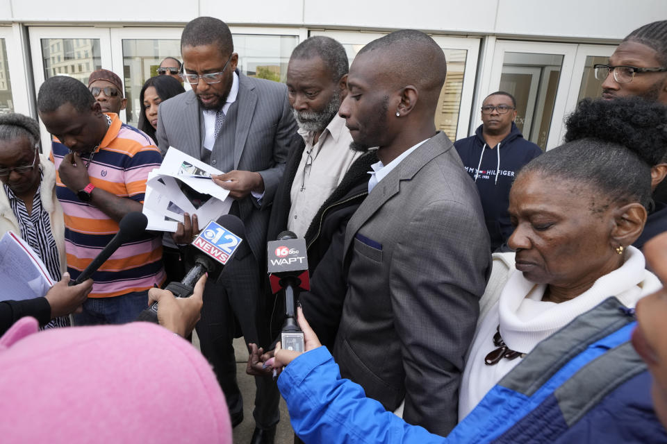 Lead civil attorney Malik Shabazz, second from left, speaks to reporters while his clients, Eddie Terrell Parker, left, Michael Corey Jenkins, and his father Melvin Jenkins, center, and mother Mary Jenkins, right, listen while outside the federal courthouse in Jackson, Miss., Wednesday, March 20, 2024, following the federal court sentencing of the third of six former Mississippi Rankin County law enforcement officers who committed numerous acts of racially motivated, violent torture on Parker and Jenkins in 2023. (AP Photo/Rogelio V. Solis)