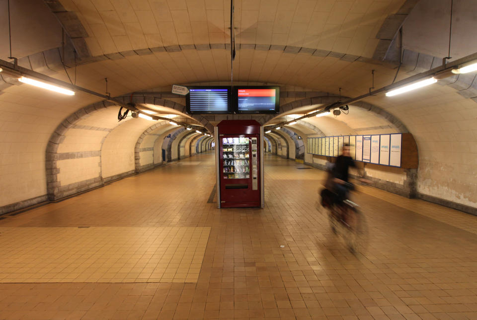 A woman cycles through a deserted hall of the main train station in Ghent, western Belgium, Wednesday, Oct. 3, 2012. A 24-hour strike by Belgian rail workers on Wednesday paralyzed train traffic throughout Belgium and the international high-speed service to London and Paris. The strike, which started late Tuesday, reached its peak during the Wednesday morning rush hour when tens of thousands of commuters had to take to traffic-choked highways to get into the capital or work. (AP Photo/Yves Logghe)