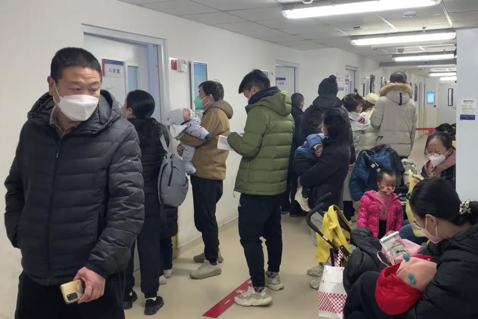 Visitors wear masks at the children's hospital n Beijing, Wednesday, Dec. 14, 2022. China's National Health Commission scaled down its daily COVID-19 report starting Wednesday in response to a sharp decline in PCR testing since the government eased antivirus measures after daily cases hit record highs. (AP Photo/Dake Kang)