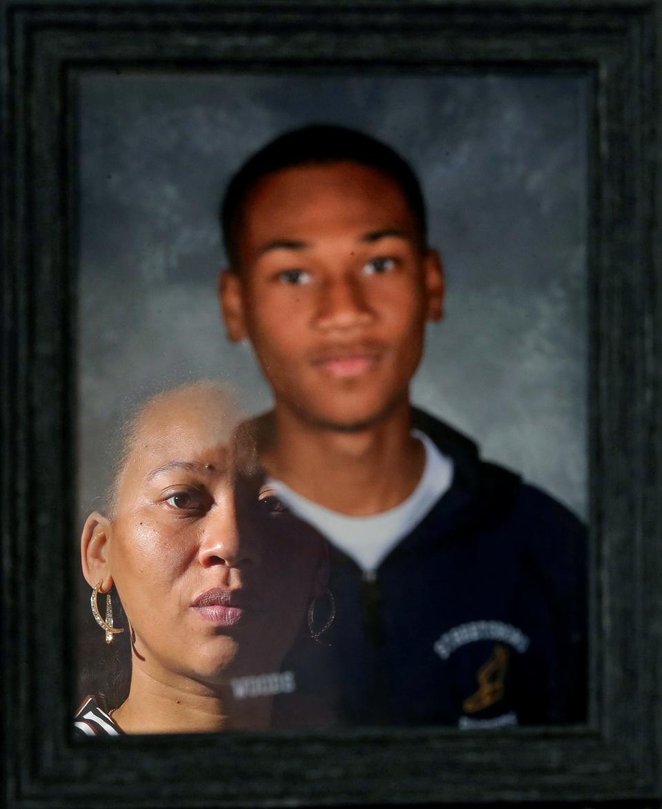 Tamia Woods is reflected in a portrait of her 17-year-old son, James, during an interview at the family's home in Streetsboro. James died by suicide in November 2022 after he became a victim of online sextortion.