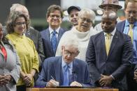 Wisconsin Gov. Tony Evers signs Assembly Bill 438 and Assembly Bill 439 at American Family Field Tuesday, Dec. 5, 2023, in Milwaukee. The bills use public funds to help the Milwaukee Brewers repair their stadium over the next three decades. (AP Photo/Morry Gash)