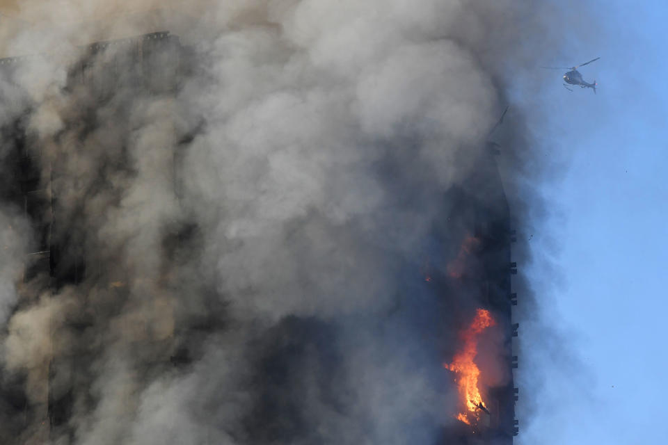 <p>A helicopter is seen as flames and smoke billow while firefighters deal with a serious fire in a tower block at Latimer Road in West London, Britain June 14, 2017. (Toby Melville/Reuters) </p>