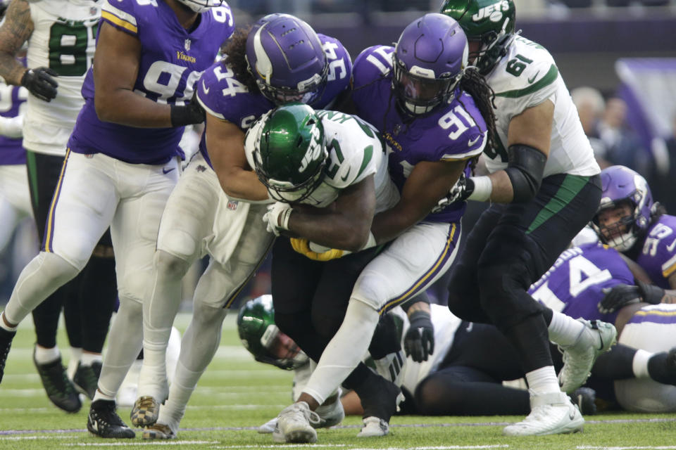 New York Jets running back Zonovan Knight (27) is tackled by Minnesota Vikings linebacker Eric Kendricks (54) and linebacker Patrick Jones II (91) during the first half of an NFL football game, Sunday, Dec. 4, 2022, in Minneapolis. (AP Photo/Andy Clayton-King)