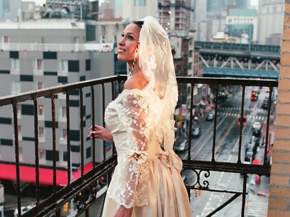 Singer Princess Nokia wears a vintage wedding dress and stands on a New York City fire escape.