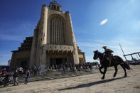 A boy rides his horse while taking part in a celebration in honor of the Virgin del Carmen, patron saint of Chile, in Santiago, Chile, Saturday, July 16, 2022. Hundreds of cowboys in woolen ponchos and families on wooden horse carts lined up to receive a priest's blessing in the huge esplanade in front of the National Sanctuary of Maipu on Saturday afternoon. (AP Photo/Esteban Felix)