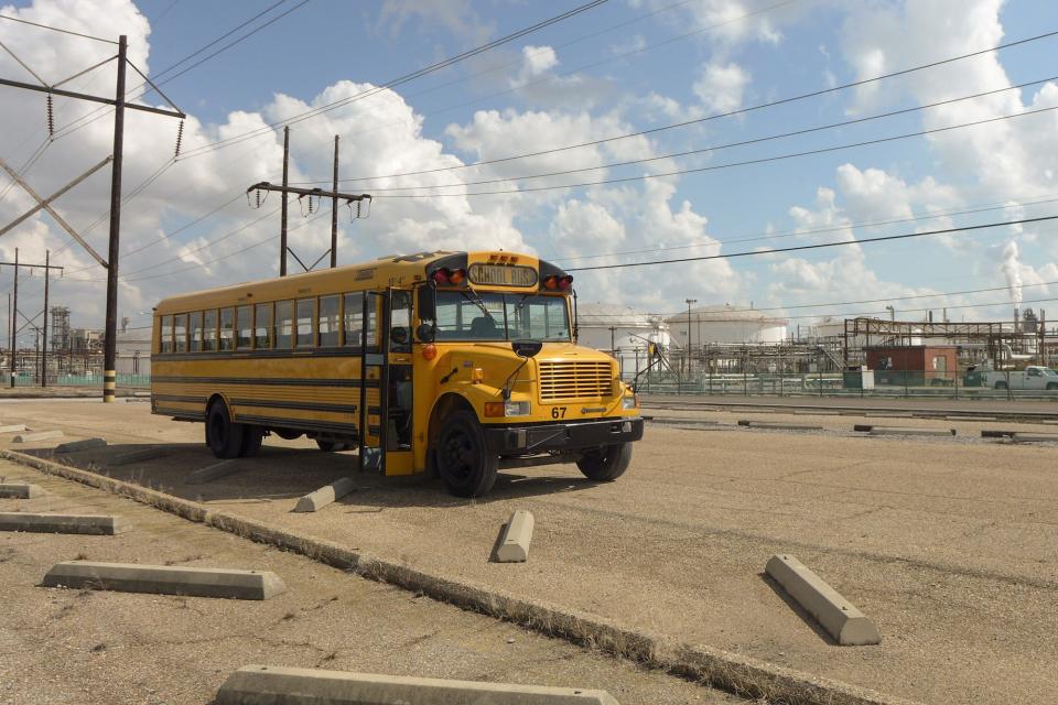 An empty school bus idles amongst a field of chemical plants in the area October 12, 2013.