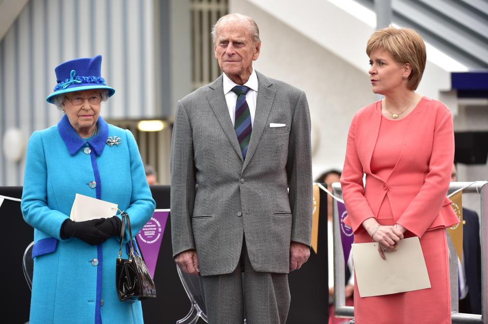 <p>La reina Isabel II (izquierda), el príncipe Felipe, (centro) y el primer ministro de Escocia, Nicola Sturgeon (derecha), en la estación Tweedbank situada en Scottish Borders el 9 de septiembre de 2015, el día que la reina se convirtió en la monarca que más tiempo ha reinado en Gran Bretaña (Leon Neal / <em>AFP</em> a través de <em>Getty Images</em>).</p> 