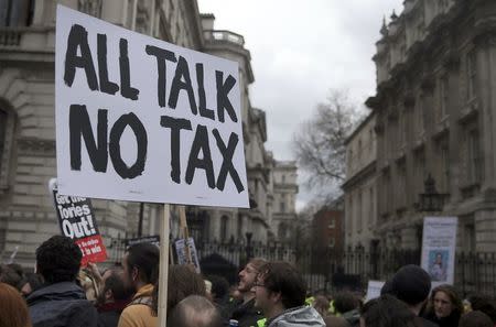 Demonstrators hold placards during a protest outside Downing Street in Whitehall, central London, Britain April 9, 2016. REUTERS/Neil Hall