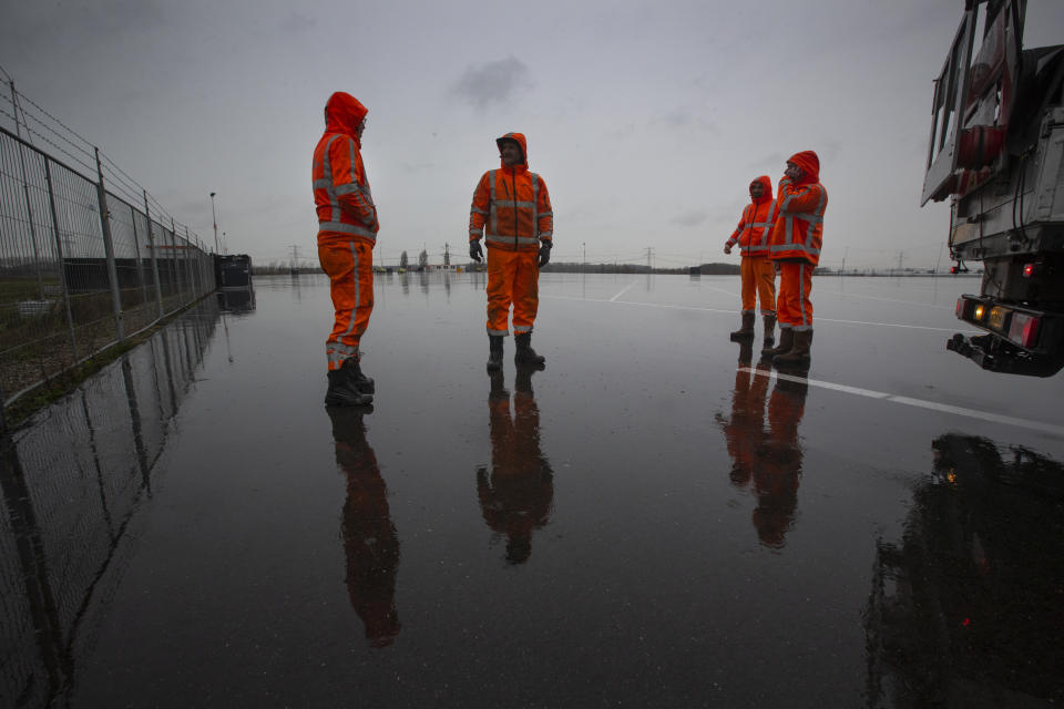 Workers finish preparations on an overflow parking lot for trucks after the Brexit transition period, in Hook of Holland, near Rotterdam, Netherlands, Monday, Dec. 21, 2020. The parking lot is being set up near Hook of Holland for trucks whose drivers have not filled in the necessary paperwork to get onto a ferry bound for England. (AP Photo/Peter Dejong)