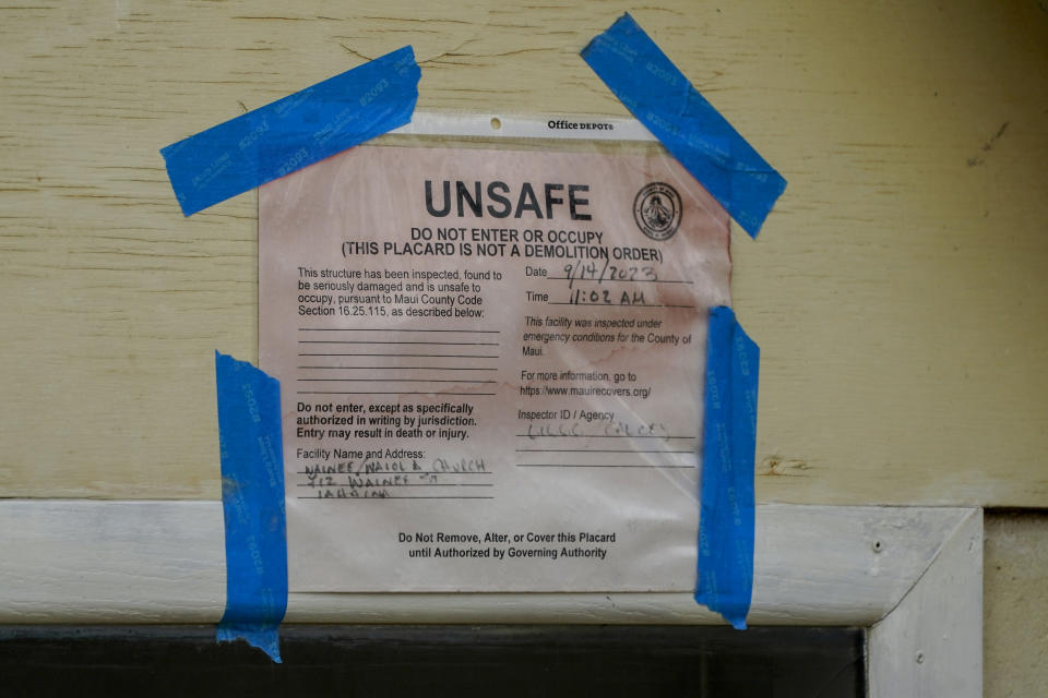 A placard marking the Waiola Church unsafe to enter is pictured, Thursday, Dec. 7, 2023, in Lahaina, Hawaii. Recovery efforts continue after the August wildfire that swept through the Lahaina community on Hawaiian island of Maui, the deadliest U.S. wildfire in more than a century. (AP Photo/Lindsey Wasson)