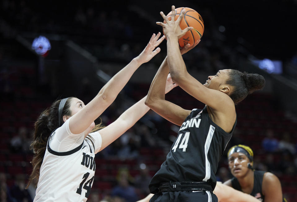 UConn forward Aubrey Griffin, right, shoots over Iowa forward McKenna Warnock during the first half of an NCAA college basketball game in the Phil Knight Legacy Championship in Portland, Ore., Sunday, Nov. 27, 2022. (AP Photo/Craig Mitchelldyer)