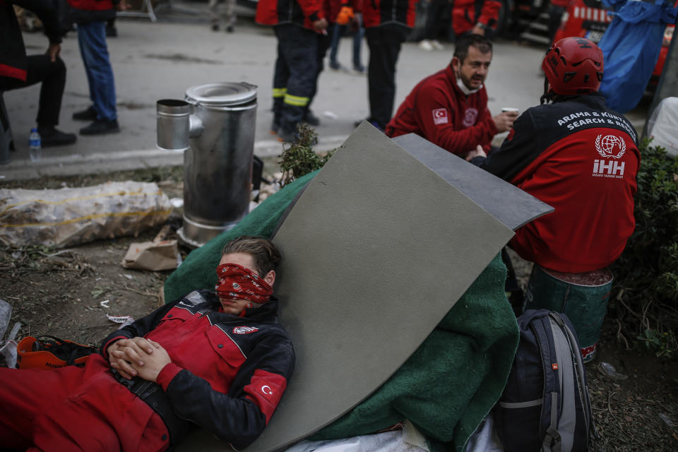 A member of rescue services takes a break during the search for survivors in the debris of a collapsed building destroyed in the earthquake in Izmir, Turkey, Tuesday, Nov. 3, 2020. Rescuers in the Turkish coastal city pulled a young girl out alive from the rubble of a collapsed apartment building Tuesday, four days after a strong earthquake hit Turkey and Greece. (AP Photo/Emrah Gurel)