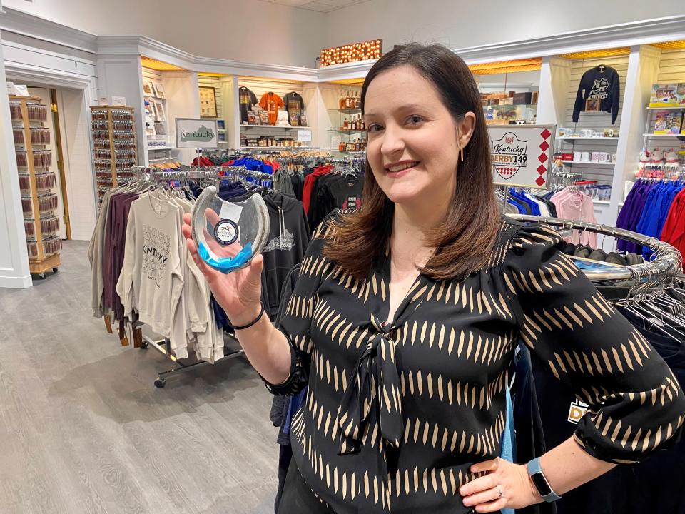 Kristina Gerard holds a popular item at the Kentucky Derby Museum Store. The Dirty Horse Shoe is an $8 horse shoe with dirt from Churchill Downs Racetrack embedded in the grooves.