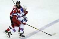 New Jersey Devils center Jack Hughes (86) grabs New York Rangers left wing Chris Kreider (20) during the first period of an NHL hockey game, Tuesday, April 13, 2021, in Newark, N.J. (AP Photo/Kathy Willens)