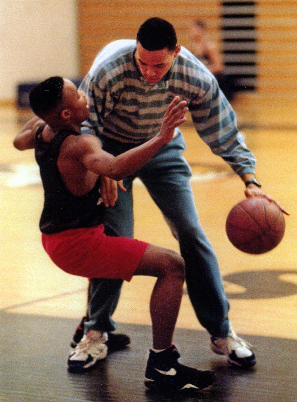Former Buchtel basketball coach Harvey Sims shows Julian Logan the kind of charge he may face in the 1994 regional tournament.