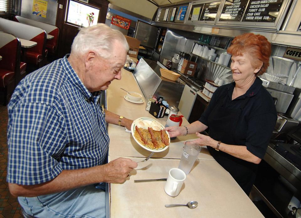 In this July 13, 2006 photo, Reese Hickman is served blueberry pancakes with eggs sunny side up, bacon and syrup by waitress Jessie Donovan at Doyle's Restaurant in Selbyville.