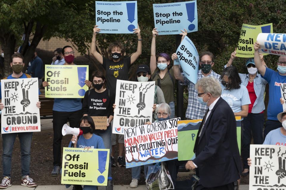 FILE - Demonstrators against the Mountain Valley Pipeline protest at Northern Virginia Community College where gubernatorial candidates, Terry McAuliffe and Glenn Youngkin are debating each other, in Alexandria, Va., Tuesday, Sept. 28, 2021. The hotly contested East Coast natural gas pipeline was given the go-ahead Tuesday, June 11, 2024, to start operating, six years after construction began at more than double its original estimated cost. (AP Photo/Cliff Owen, File)