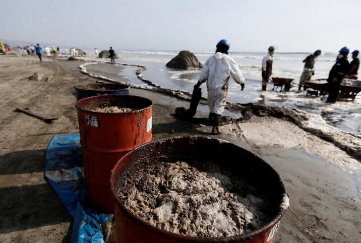 IMAGEN DE ARCHIVO. Trabajadores limpian un derrame de petróleo, en medio del descarge de un tanquero, causado por olas anormales provocadas por una erupción volcánica submarina en Tonga, frente a la costa de Lima, en Ventanilla, Perú,