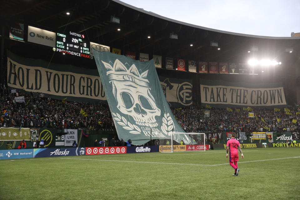 Portland Timbers goalkeeper Steve Clark (12) walks onto the pitch as a tifo is displayed before the MLS soccer Western Conference final between the Timbers and Real Salt Lake on Saturday, Dec. 4, 2021, in Portland, Ore. (AP Photo/Amanda Loman)