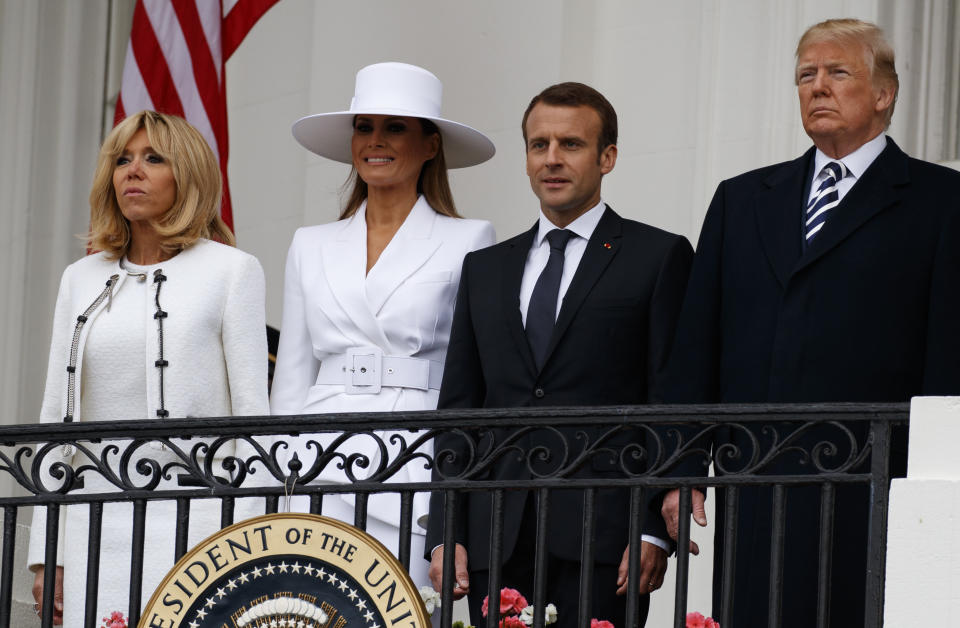 El sombrero blanco de Melania Trump captó la atención y contrastó, al menos en la foto, con la expresión de su contraparte Brigitte Macron, y de los presidentes de Francia y Estados Unidos. (AP)