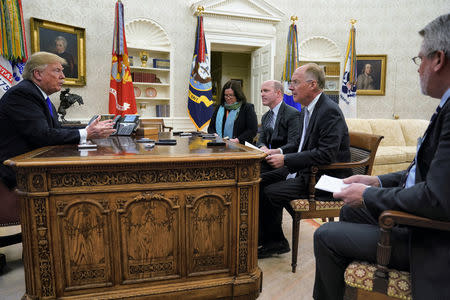 U.S. President Donald Trump sits for an exclusive interview with Reuters journalists Roberta Rampton, Jeff Mason and Steve Holland as White House Communications Director Bill Shine (R) looks on in the Oval Office at the White House in Washington, U.S. December 11, 2018. REUTERS/Jonathan Ernst