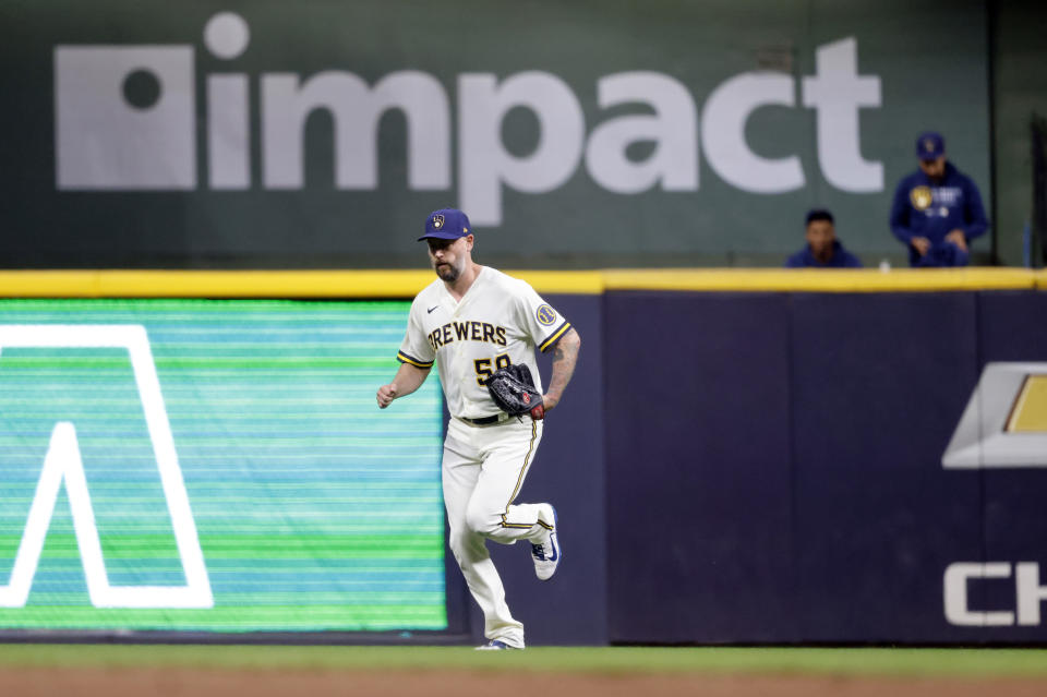 Milwaukee Brewers' John Axford enters a baseball game against the Pittsburgh Pirates during the ninth inning Monday, Aug. 2, 2021, in Milwaukee. (AP Photo/Jeffrey Phelps)