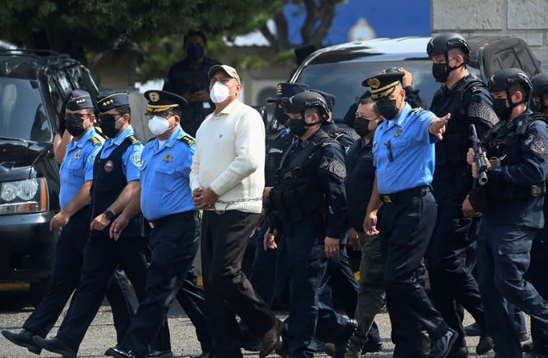 La policía hondureña y las fuerzas especiales escoltan al exjefe policial Juan Carlos Bonilla, alias "El Tigre", hasta un avión para su extradición a Estados Unidos, en una base de la Fuerza Aérea en Tegucigalpa, el 10 de mayo de 2022 (Orlando Sierra)