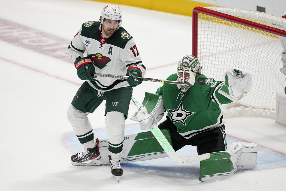 Minnesota Wild left wing Marcus Foligno (17) pressures the net as Dallas Stars goaltender Jake Oettinger (29) defends against a shot in the third period of Game 2 of an NHL hockey Stanley Cup first-round playoff series, Wednesday, April 19, 2023, in Dallas. (AP Photo/Tony Gutierrez)