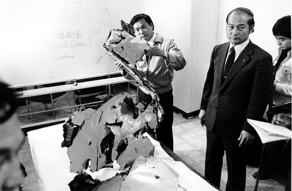 FILE - In this Sept. 12, 1983, file photo, Korean Airlines equipment procurement section chief Suk Jin-Ku examines a piece of aircraft debris at Wakkania Police station in Japan. Those searching for the truth about what happened in the shoot-down of the Malaysia airliner over Ukraine can take little comfort from the history of another passenger jet that was blasted out of the sky over the Soviet Union more than three decades ago: The Kremlin at the time dodged, weaved and obfuscated. Today, we still don’t know what exactly happened to Korean Airlines Flight 007. (AP Photo/Mikami, File)