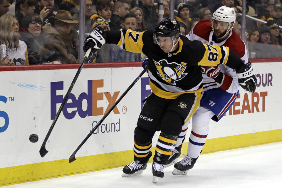 Pittsburgh Penguins' Sidney Crosby (87) works to control the puck with Montreal Canadiens' Marco Scandella (28) defending during the second period of an NHL hockey game in Pittsburgh, Friday, Feb. 14, 2020. (AP Photo/Gene J. Puskar)