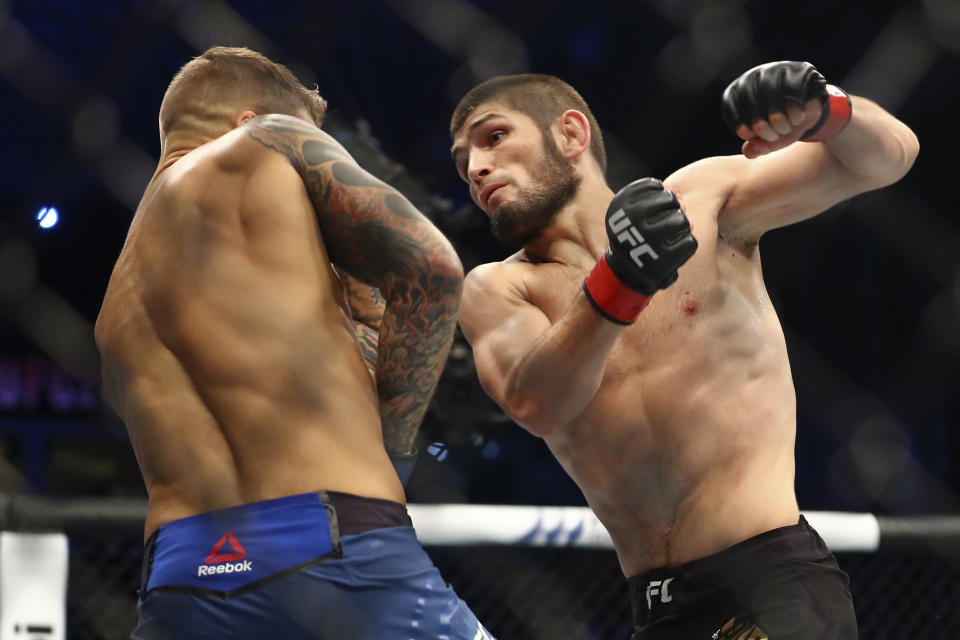 FILE - In this Sept. 7, 2019, file photo, Russia's Khabib Nurmagomedov, right, fights with Dustin Poirier, of Lafayette, La., during a lightweight title mixed martial arts bout at UFC 242 in Yas Mall in Abu Dhabi, United Arab Emirates. Nurmagomedov will risk his unbeaten record and his UFC lightweight title against interim champion Justin Gaethje in the main event of UFC 254 in Abu Dhabi on Saturday, Oct. 24, 2020. (AP Photo/Mahmoud Khaled, File)