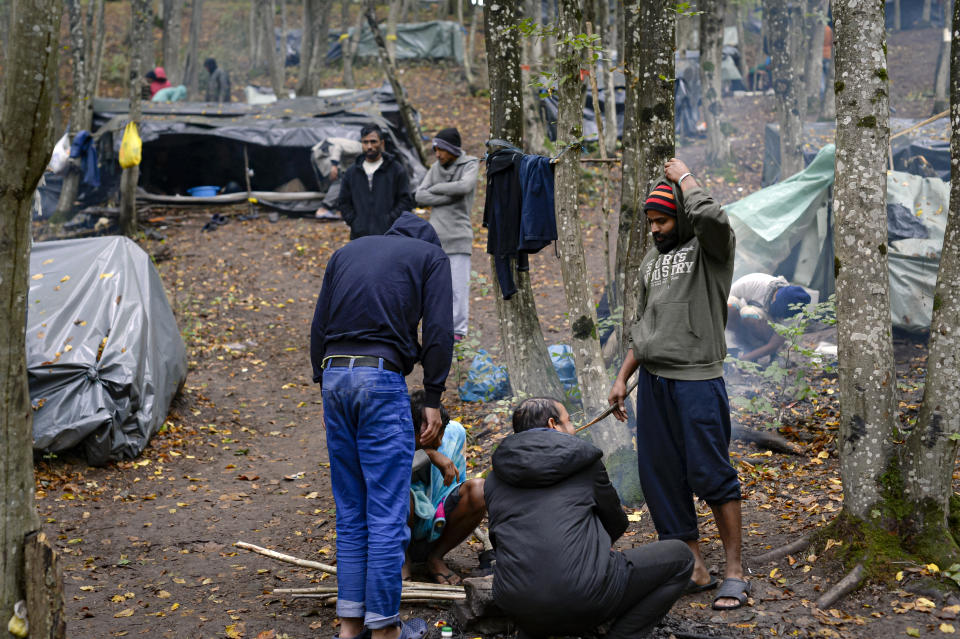 Migrants stand around improvised tents in a makeshift camp outside Velika Kladusa, Bosnia, Saturday, Sept. 26, 2020. Remote woods, abandoned run-down buildings and roadsides on the fringes of northwestern Bosnian towns are steadily filling with makeshift camps where migrants from the Middle East, Asia and North Africa are bracing for more misery as autumn's chill and rains set it. (AP Photo/Kemal Softic)